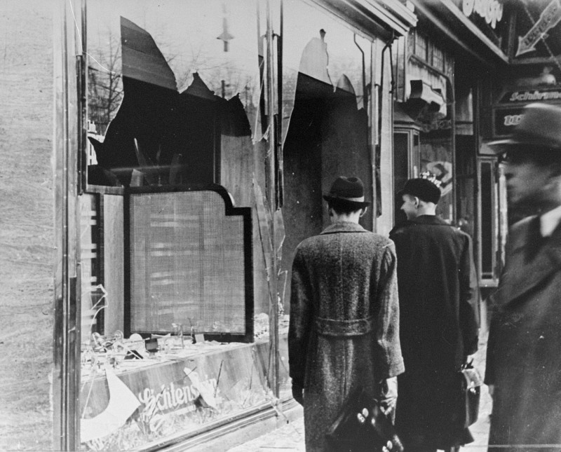 Shattered storefront of a Jewish-owned shop destroyed during Kristallnacht (the "Night of Broken Glass"). [LCID: 86838]