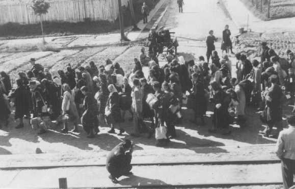 <p>Ghetto photographer Mendel Grossman (foreground) takes photos of a deportation. Lodz ghetto, Poland, June-August 1944.</p>