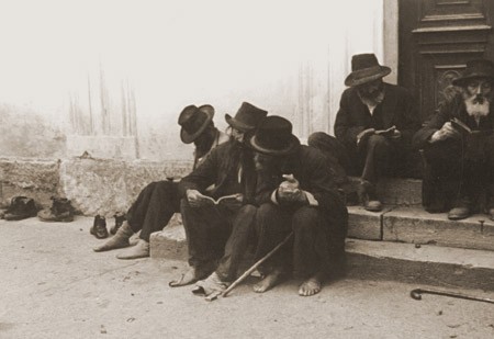 Jewish men sitting on the steps of a synagogue. Munkacs, Czechoslovakia, 1936. [LCID: 96587]