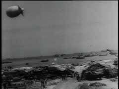El desembarco aliado masivo de fuerzas aéreas y marítimas en cinco playas de Normandía (con el nombre en código de Utah, Omaha, Gold, Juno y Sword) comenzó el 6 de junio de 1944 (Día D). El objetivo de la invasión era establecer una cabeza de playa desde donde las fuerzas aliadas pudieran salir y liberar Francia. Para el final del primer día de la operación, unas 150.000 tropas habían desembarcado en Normandía. Esta secuencia filmada muestra el desembarco de las fuerzas aliadas en las playas de Normandía.