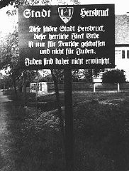 لافتة خارج إحدى المدن في مدينة بافاريا الشمالية تحمل التحذير: "مدينة هيرسبروك. وقد تم إنشاء مدينة هيرسبروك الجميلة هذه، تلك البقعة الخلابة فوق سطح الأرض للألمان فقط وليس لليهود. ولهذا فاليهود غير مرغوب فيهم هنا." هيرسبروك، ألمانيا، 4 أيار/مايو، عام 1935.