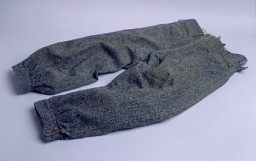Pants worn by Marjan Glass as he dug anti-tank ditches for the defense of Warsaw, Poland, and then as he hastily fled the city ahead of the German advance on September 7, 1939. Glass, a lawyer, escaped with his wife and three-year-old son, and his wife's mother and brother. He left without taking the time to change from his soiled work clothing. [From the USHMM special exhibition Flight and Rescue.]