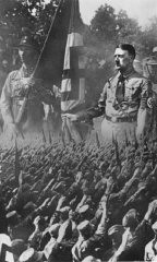 Hitler ve bir Nazi fırtına birliği askerinin büyütülmüş resmi ve selam veren Almanların fotoğrafının birleştirildiği bir kartpostal. Münih, Almanya, 1932 civarı.