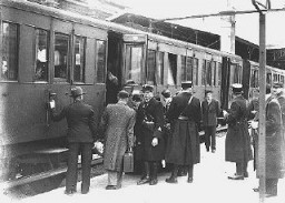 Jewish deportees, guarded by French police, board a train at the Austerlitz station for transport to the Pithiviers internment camp. Paris, France, May 1941.