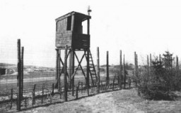 A view of one of the watchtowers and part of the perimeter fence at Ohrdruf, part of the Buchenwald camp system, seen here after US forces liberated the camp. Ohrdruf, Germany, April 1945.