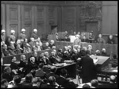 US prosecutor Thomas Dodd introduces the film compilation "Nazi Concentration Camps." At the end of the courtroom scene shown here, the lights are dimmed for the screening. The footage, filmed as Allied troops liberated the concentration camps, was presented in the courtroom on November 29, 1945, and entered as evidence in the trial.