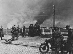 Exército alemão nos arredores de Varsóvia. Ao fundo, a cidade queima após a ofensiva militar alemã. Varsóvia, Polônia, setembro de 1939.