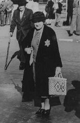Una donna anziana, ebrea tedesca, indossa il distintivo obbligatorio che la identifica come appartenente alla razza ebraica. 27 settembre 1941.