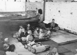 کودکان در سیساک، اردوگاه اوستاشا (کرواسی فاشیست ) برای کودکان،  روی زمین نشسته و خوابیده‌اند. یوگسلاوی، هنگام جنگ جهانی دوم.
