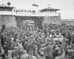 Sobrevivientes de Mauthausen aclaman a soldados estadounidenses mientras pasan por la puerta principal del campo. La fotografía fue tomada varios días después de la liberación del campo. Mauthausen, Austria, 9 de mayo de 1945.