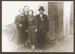 Portrait of the Weidenfeld family wearing Jewish badges in the Czernowitz (Cernauti) ghetto shortly before their deportation to Transnistria. Pictured from left to right are Yetty, Meshulem-Ber, Sallie, and Simche Weidenfeld. Cernauti, Romania, October 1941.