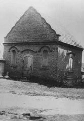 Photographie d’après-guerre d’un immeuble de Dabie où les biens des Juifs assassinés dans le camp voisin de Chelmno étaient entreposés. Dabie, Pologne, juin 1945.