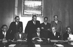 Perwakilan dari empat negara yang meratifikasi Konvensi Genosida pada 14 Oktober 1950: (duduk, kiri ke kanan) Dr. John P. Chang (Korea), Dr. Jean Price-Mars (Haiti), Ketua Majelis Dubes Nasrollah Entezam (Iran), Dubes Jean Chauvel (Prancis), Ruben Esquivel de la Guardia (Kosta Rika), (berdiri, kiri ke kanan) Dr. Ivan Kerno (Asisten Sekretaris Jenderal untuk Urusan Hukum), Trygve Lie (Sekretaris Jenderal PBB), Manuel A. Fournier Acuna (Kosta Rika), dan Dr. Raphael Lemkin (pejuang untuk terbentuknya Konvensi Genosida). Lake Success, New York, 14 Oktober 1950