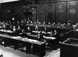 The defendants in the dock (at rear, with headphones) and their lawyers (front) follow the proceedings of the Hostage Case, case #7 of the Subsequent Nuremberg Proceedings. Nuremberg, Germany, 1947-48.
