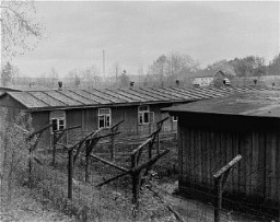 The barbed-wire fences and prisoner barracks after liberation at Ebensee, a subcamp of the Mauthausen concentration camp. Austria, May 1945.
