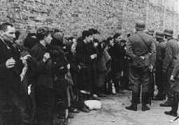 وارسا یہودی بستی کی بغاوت کے دوران گرفتار کردہ یہودیوں سے جرمن سپاہی تفتیش کرتے ہوئے۔ پولینڈ، مئی 1943۔