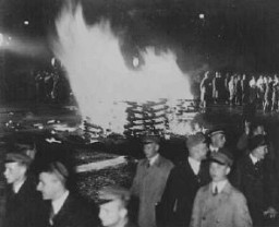 حرق الكتب "الغير ألمانية" في ساحة أوبرنبلاتس ببرلين. طلاب وبعضهم لابسين بذلات جيش الإنقاذ يسيرون في صف بالمشاعل. ألمانيا. 10 مايو 1933.