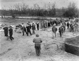 Under the supervision of the US First Army, German civilians from Nordhausen carry victims of the Dora-Mittelbau concentration camp to mass graves. Germany, April 14, 1945.