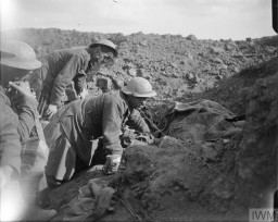 Siperdeki İngiliz birlikleri, Kasım 1916’da Somme Muharebesi sırasında öldürülen iki dost askerin bedenlerini örtüyor. © IWM (Q 4393)