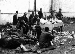 Раненые советские военнопленные в ожидании медицинской помощи. Германская армия обеспечивала военнопленным лишь минимальный медицинский уход; пленным советским врачам разрешалось лечить своих раненых, используя только те медикаменты и принадлежности, которые были у них при себе. Барановичи, Польша, во время войны.