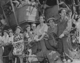 Menekültek gyülekeznek a „Josiah Wedgwood” nevű hajó korlátjánál a haifai kikötőben az Aliyah Bet („illegális” bevándorlás) során. A brit katonák az Atlit internálóközpontba szállították az utasokat. Palesztina, 1946. június 27.