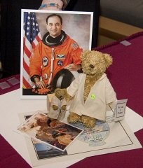 A replica of "Refugee" bear and a photo of a Darfurian child refugee, items taken by Commander Mark Polansky (pictured) on a December 2006 Space Shuttle mission.