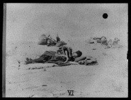 Армянские беженцы в пустыне. Мужчина на переднем плане лежит на спальных принадлежностях, брошенных на землю, 1915-1920 годы.