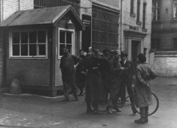 Police search a messenger at the entrance to the building where Vorwaerts, a Social-Democratic Party newspaper, was published. The building was subsequently occupied during the suppression of the political left wing in Germany that was carried out in response to the Reichstag Fire. Berlin, Germany, March 3–4, 1933.