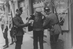 Police search in Berlin. Members of the SA stand nearby. Berlin, Germany, 1933.
