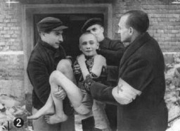 Вскоре после освобождения – советские санитары выносят истощенного ребенка из лагерного барака. Освенцим, Польша, после 27 января 1945