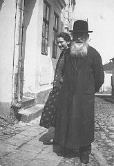 ایزاک زالشوتز و دخترش، راشل جلوی خانه خود ایستاده‌اند. کولبوزوا، لهستان، ۱۹۳۷.