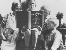 Enfants allemands lisant un livre de propagande antisémite intitulé DER GIFTPILZ ( “Le champignon vénéneux”). La fille sur la gauche tient un complément, dont le titre traduit est “Ne faites pas confiance au renard.” Allemagne, vers 1938.