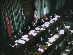 Международный военный трибунал являлся судебным органом, который был совместно создан победившими союзными державами. Позади столов судей висят флаги Советского Союза, Великобритании, США и Франции.