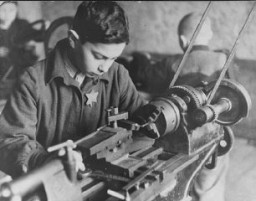 Еврейский мальчик во время принудительных работ на фабрике в гетто. Каунас, Литва, между 1941 и 1944 годами.