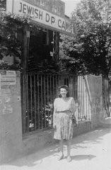 This photograph shows Dina Sarna in front of a sign saying "Jewish DP Camp" in the Bad Reichenhall camp for Jewish displaced persons. Bad Reichenhall, Germany, 1947.