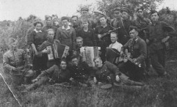 白俄罗斯纳罗赫森林 (Naroch Forest) 中的犹太游击队队员，他们当中有一支小歌舞队。除了武装抵抗外，犹太抵抗组织还着重进行精神抵抗，努力保留自己的传统和文化。拍摄地点：苏联；拍摄时间：1943 年。