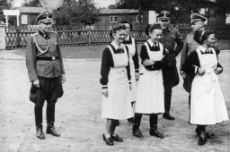 SS officers and German nurses gather during the dedication ceremony of the new SS hospital in Auschwitz, September 1, 1944. Among those pictured are Karl Höcker, Josef Kramer, and SS-Hauptsturmführer Heinrich Schwarz.