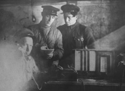 Vasiliy Nikitich Semyonov, chief of staff of the Shish detachment of the Molotov partisan brigade, makes a telephone call from a partisan bunker. Photograph taken by Faye Schulman.