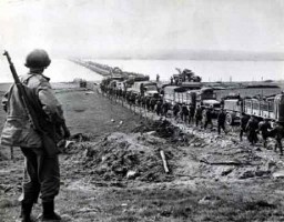 German prisoners file across the Rhine as American supply trucks move forward toward the front. March 26, 1945. US Army Signal Corps photograph.