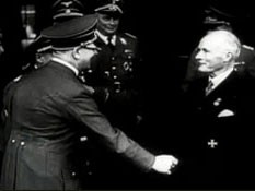 Hitler congratulates industrialist Gustav Krupp after presenting him with a Nazi party honor. After the ceremony, they toured a Krupp factory. This footage comes from the film "The Nazi Plan," produced and used by the United States in the prosecution at the Nuremberg trials.