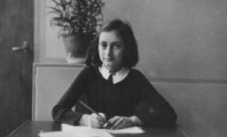 آنه فرانک در دوازده سالگی، پشت میز مدرسه‌اش. آمستردام، هلند، ۱۹۴۱