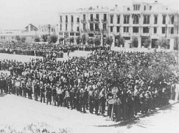 Περίπου 7.000 άρρενες Εβραίοι που πήραν την εντολή  να καταγραφούν σε καταλόγους καταναγκαστικής εργασίας συγκεντρώνονται στην πλατεία Ελευθερίας στην κατεχόμενη από τη Γερμανία Θεσσαλονίκη. Θεσσαλονίκη, Ελλάδα, Ιούλιος 1942.