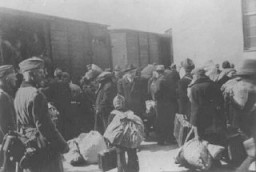 Aleksander Belev, Bulgarian commissioner for Jewish Affairs (center, wearing hat and facing the camera), oversees the deportation of Jews. Skopje, Yugoslavia, March 1943.