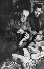Jewish forced laborers at work making shoes in a ghetto workshop. Kovno, Lithuania, December 1943.