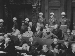 뉘렌베르그에서 전범에 대한 국제 군사 법정 재판이 진행되는 동안 검사측 기소를 듣는 피고인. 1945년 11월 22일