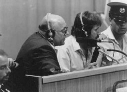 Подсудимый Джон Демьянюк дает комментарии относительно документов, демонстрируемых на большом экране в зале суда. Иерусалим, Израиль, 27 июля 1987 года.