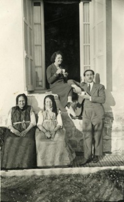 Reine (seated in window) and Yishua Ghozlan (standing) were married in Constantine, Algeria, on March 29, 1932. They are pictured here with two of their parents. 
The couple experienced antisemitism in the prewar years, and in 1933 Reine and Yishua survived a deadly pogrom by hiding with French Christian friends. After the start of World War II, Yishua was thrown out of his position in the post office. Reine, Yishua, and their children were evicted from their apartment.