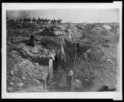 Scene of trench warfare: an abandoned British trench which was captured by German forces during World War I. German soldiers on horseback view the scene.
