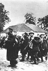 A column of prisoners arrives at the Belzec killing center. Belzec, Poland, ca. 1942.
In early 1940 the Germans set up a forced-labor camp for Jewish prisoners in Belzec. The inmates were forced to build fortifications and dig anti-tank ditches along the demarcation line between Germany and Soviet-occupied Poland. The camp was closed down at the end of 1940. The following year, in November 1941, construction began on the Belzec killing center.