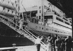 Réfugiés juifs d’Allemagne nazie, passagers à bord du “Saint Louis,” débarquant dans le port de Anvers, Cuba et les Etats-Unis ayant refusé de laisser les réfugiés débarquer. La police belge garde la passerelle. Anvers, Belgique, 17 juin 1939.